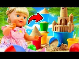 Baby dolls go to the beach and play with sand toys & sand molds. Videos for kids with girls' toys.