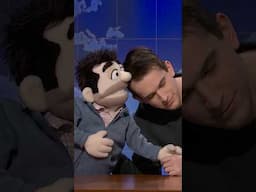 andrew and his puppet father perform their routine at the desk