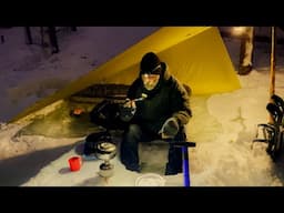 Solo tarp camping in winter forest.