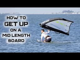 How to get up on a mid length board